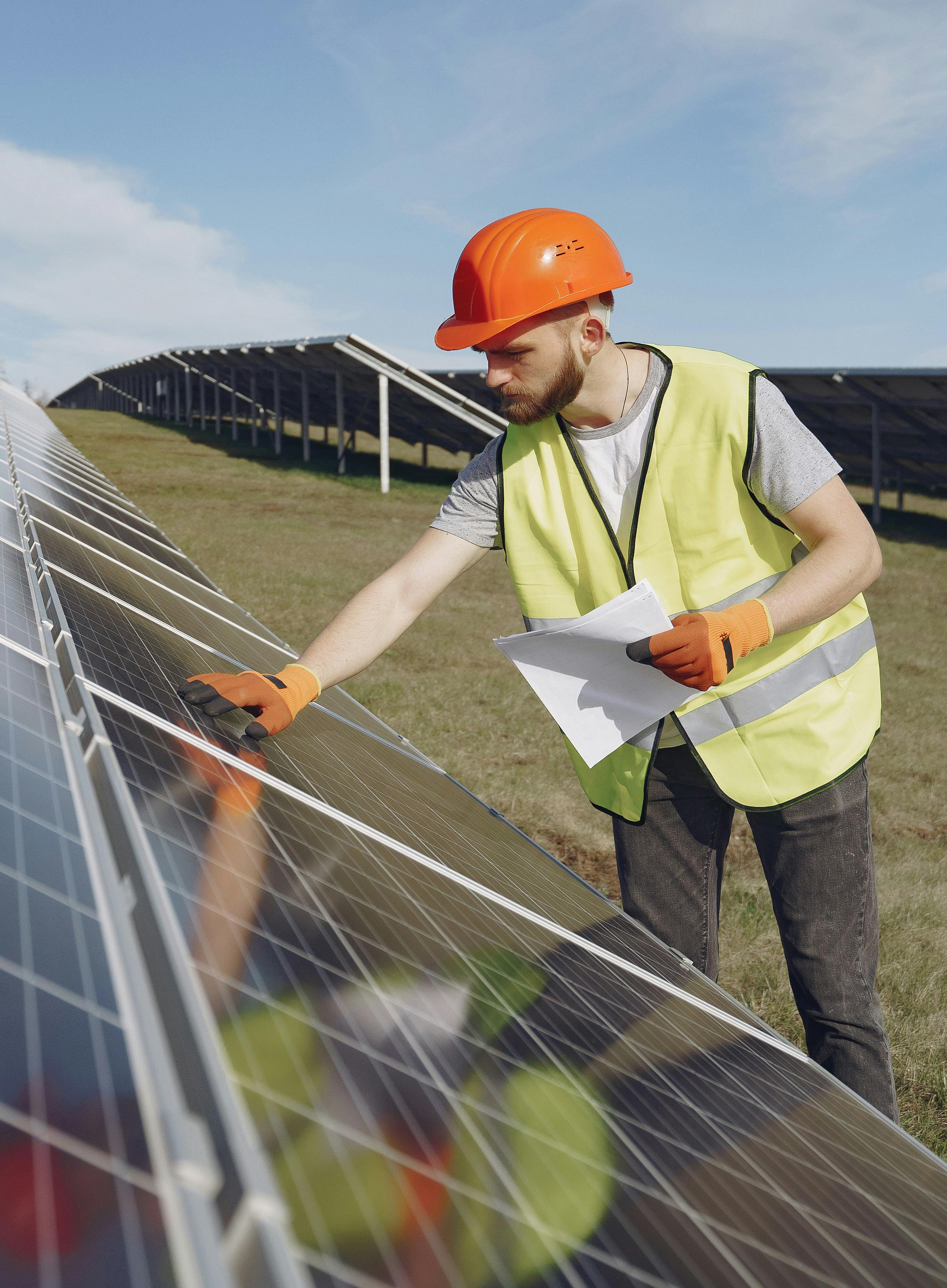 Worker examining solar panel.